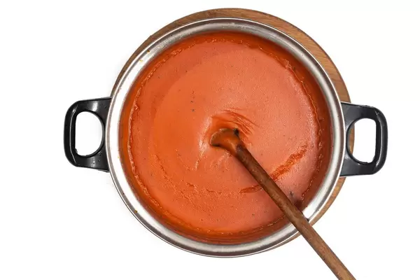 Flat lay above fresh domestic homemade tomato sauce isolated over white background