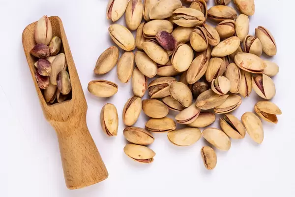 Flat lay above Pistachios with wooden Spatula