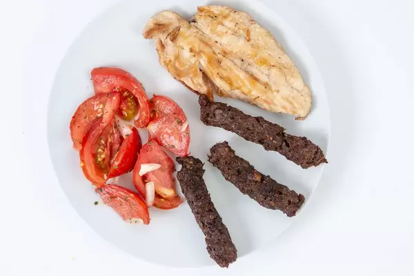 Flat lay above served grilled Chicken Breasts with Kebabs and Tomatoes (Flip 2019)