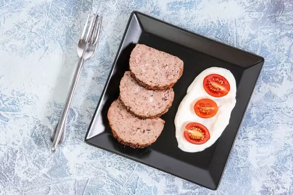Flat lay above Served Pork and Chicken Meat Loaf with Tomatoes
