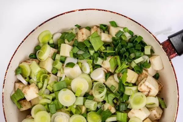 Flat lay above sliced Eggplant with Leek in the frying pan