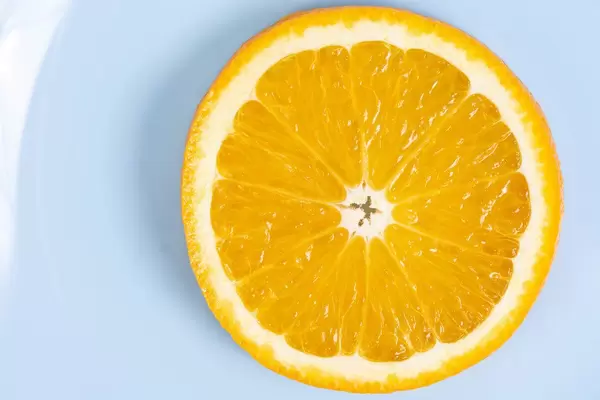 Flat lay above sliced Orange fruit on the blue plate