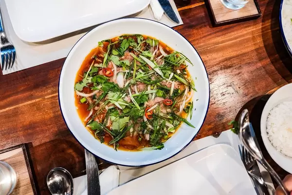 Flat lay of a delicious pork dish with special sauce and vegetables (Flip 2019)