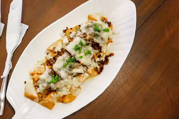 Flat lay of baked potatoes with cream sauce