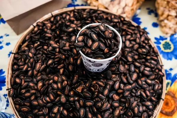Flat lay of fresh sunflower seeds in a basket
