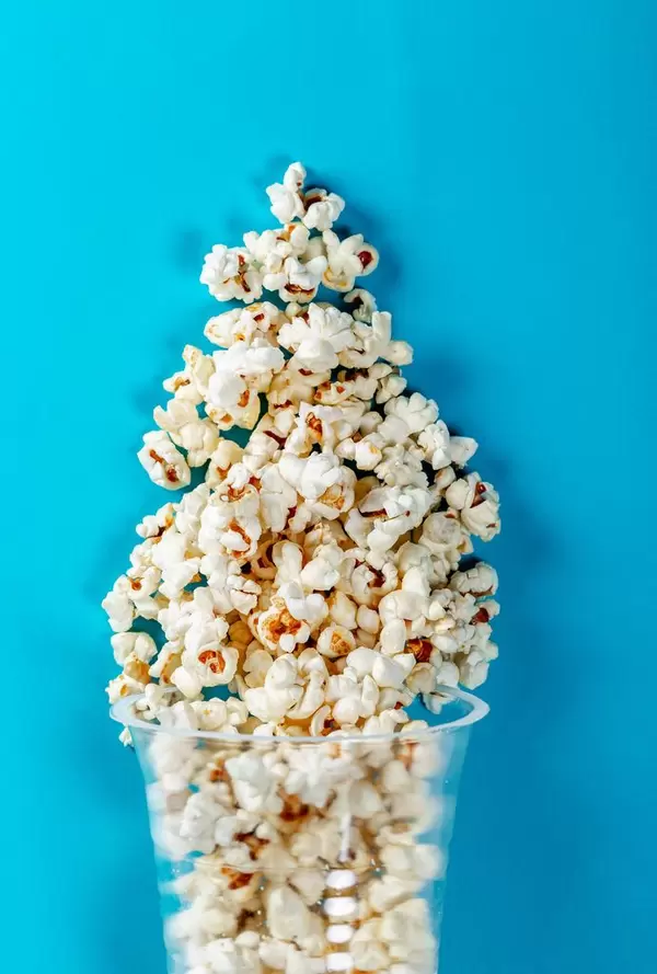 Flat lay of popcorn cup on a blue background. Top view