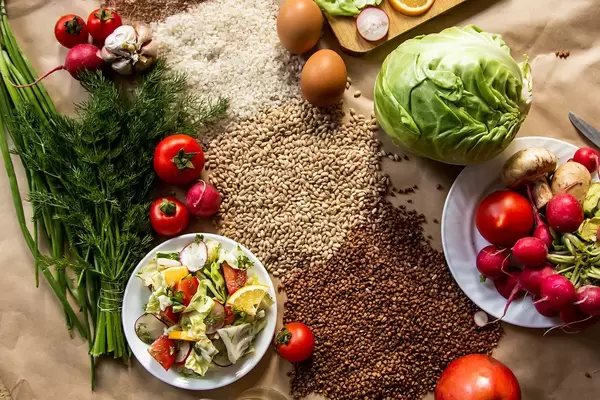 Flatlay Ansicht von veganem Essen und Getreide, auf Küchen-Backpapier ausgebreitet