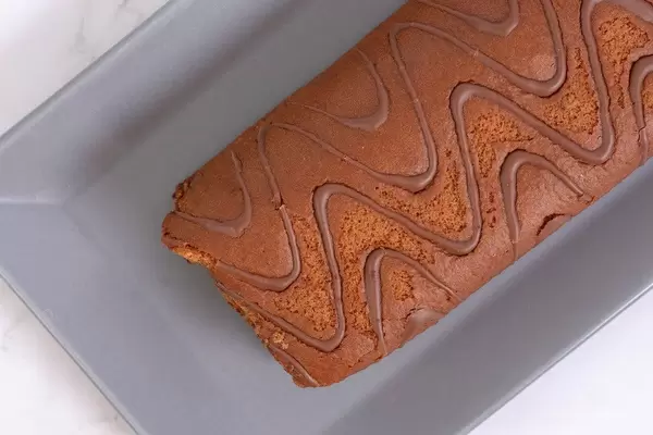 Flatlay eines Schokoladen-Biskuitkuchen auf einem Kuchentablett