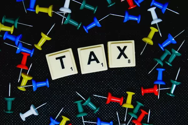 Flatlay of pins with Tax text on black background