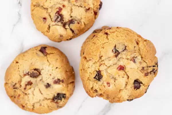 Flatlay von drei kreisförmigen Rosinenkeksen auf einer Marmoroberfläche