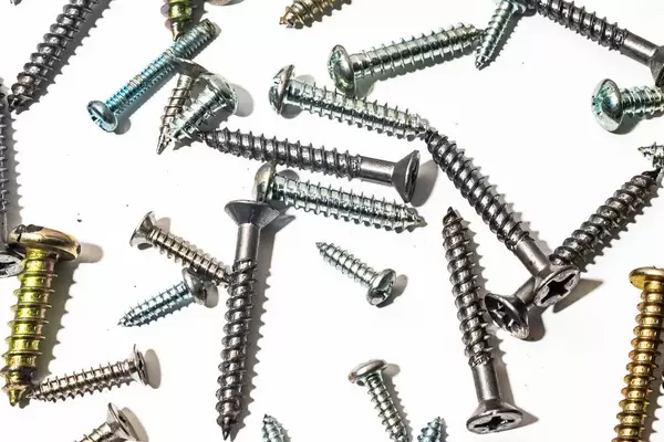 Flatlay von Schrauben auf weißer Fläche