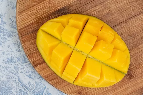 Flatlay zeigt einen Mangoigel auf einem Holzbrettchen
