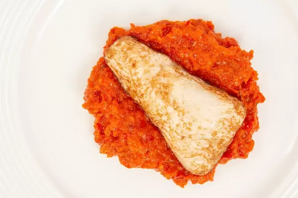 Flatlay zeigt Hühnchenbrustfilet in scharfer Chilisauce mit dem Gemüsekaviar Ajvar