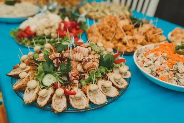Fleischröllchen mit Speck und Salat auf einem bedeckten Tisch