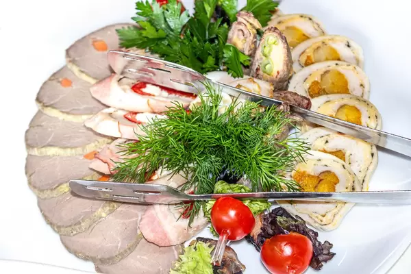 Fleischrollen mit getrockneten Aprikosen, Gemüse, gebackenem und geschnittenem Fleisch und frischen Kräutern