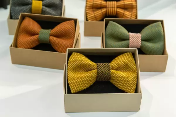 Fliegen für Herrenanzüge aus grob gewobenem Stoff in Kartonschachtel auf weißem Tisch