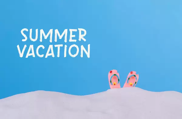 Flip flops on the beach with Summer vacation text