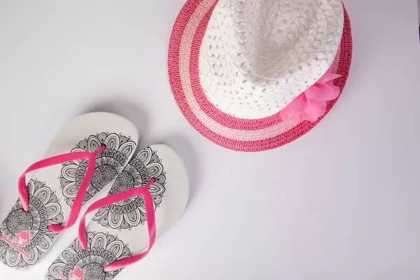 Flip-Flops und Sonnenhut als stilvolle weiß-pinke Accessoires für heiße Sommertage