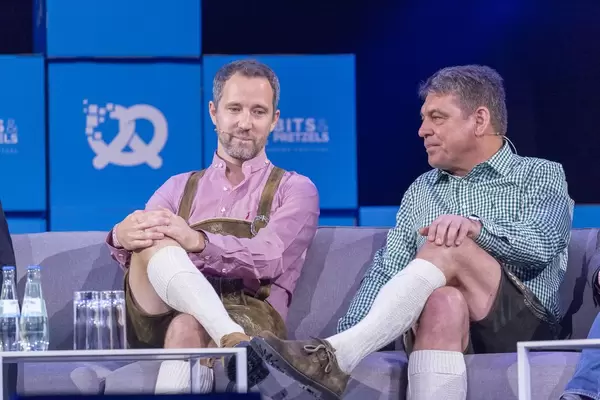 Florian Reuter und Dr. Carsten Breitfeld sitzen Beine verschränkt auf Sofa