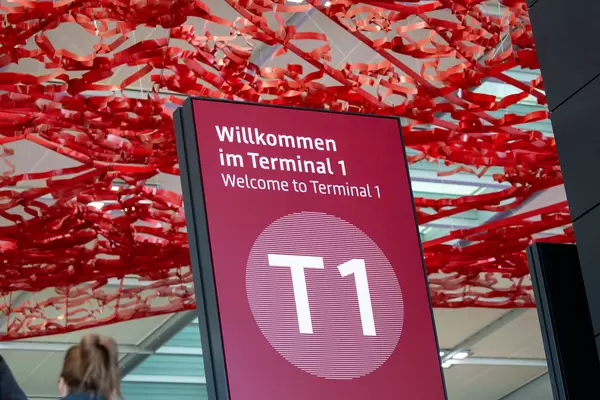 Flughafen BER: Schild "Willkommen im Terminal 1 / Welcome to Terminal 1" und "Der fliegende Teppich"