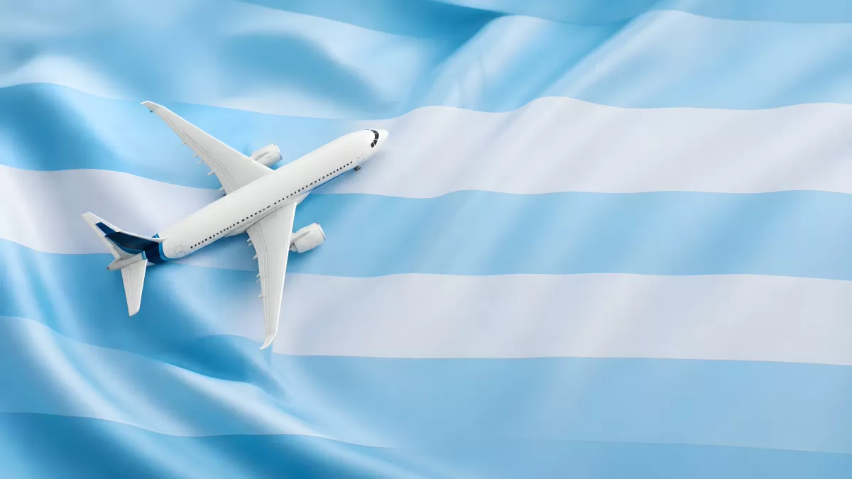 Flugzeugmodell über hellblau-weißer Flagge Argentiniens