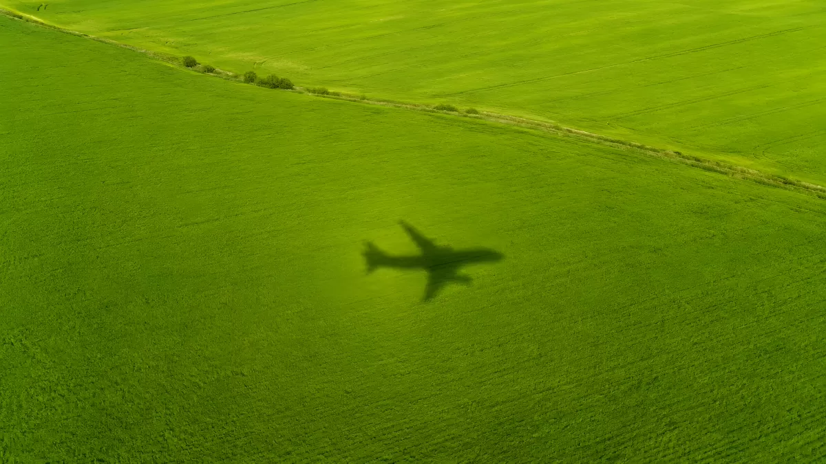Flugzeugschatten über sattem grünem Ackerfeld
