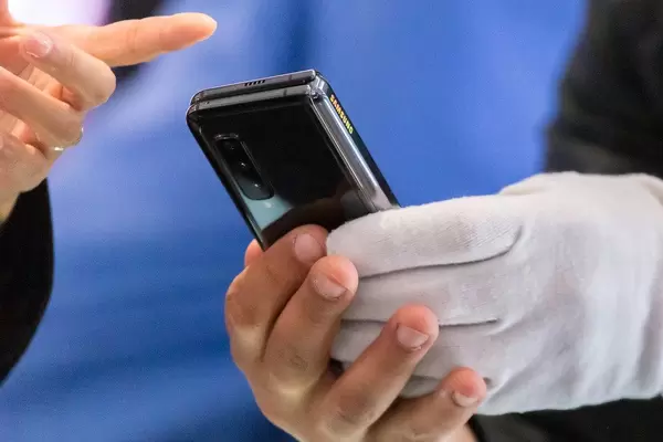 Folded Android Smartphone by Samsung: man holds the Galaxy Fold 5G dual-screen device
