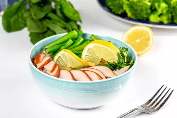 Food background with a bowl of oatmeal, chicken fillet and herbs