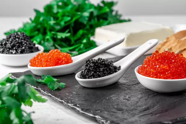 Food background with black and red caviar, butter and parsley