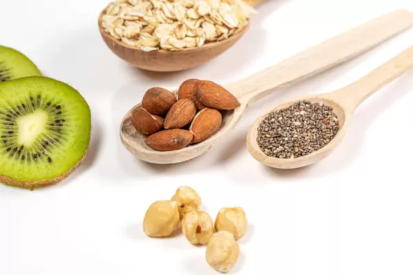 Food background with products for healthy eating in wooden spoons and on a white background