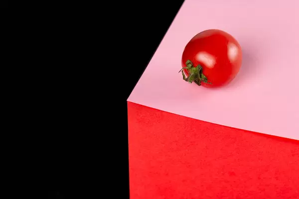 Food concept, ripe tomato on red, pink and black background
