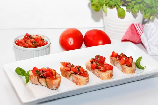 Food Photo of Tomato Bruschetta with Basil on a White Plate