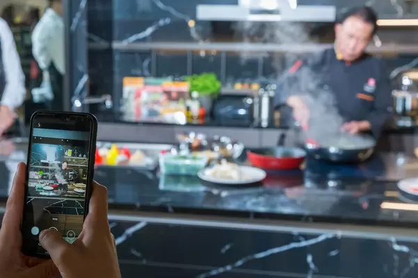 Food photography: Smartphone-Bild des chinesischen Kochs Martin Yan während einer Live-Kochshow