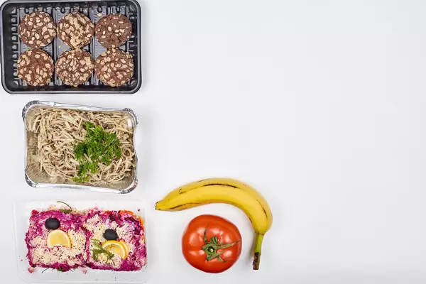 Food to go served in one-way packaging at food bank. White background with copy space to the right