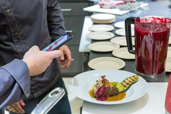 Foodstagram: Man takes picture of a colorful meal, prepared by a WMF chef at IFA-exhibition in Berlin, Germany