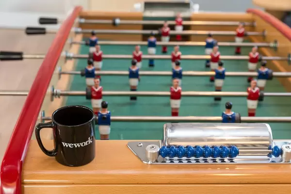 Foosball with black WeWork cup at the joint community area at the rental office in Cologne