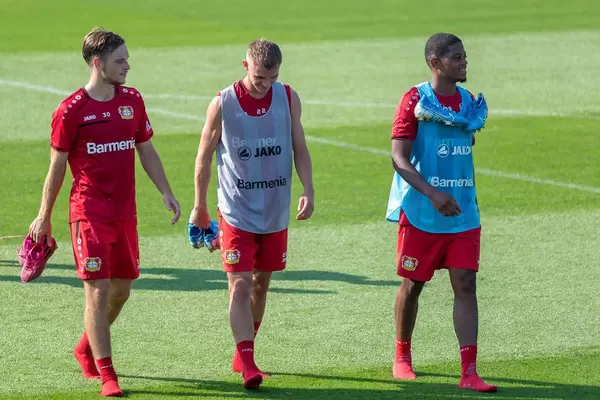 Football player Adrian Stanilewicz, Daley Sinkgraven and Leon Bailey walking barefoot over the football field in Germany, after practice