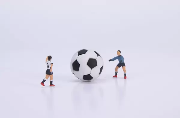 Football player and goalkeeper with ball on white background