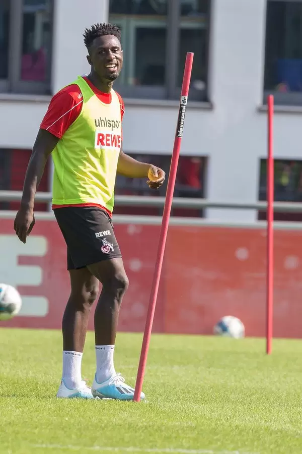 Football player Kingsley Schindler laughs during outside team training in Cologne