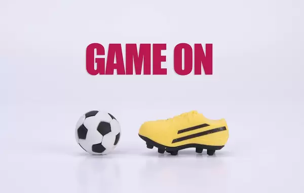 Football shoes and ball with Game on text