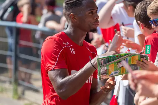 Footballer Kingsley Ehizibue gives autographs and talks to young football fans and children after his practice session