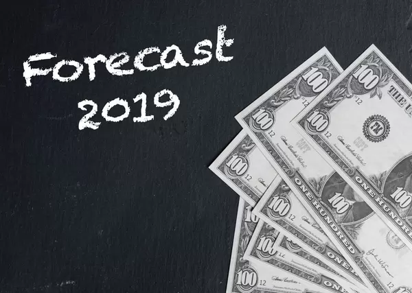 Forecast 2019 text with US dollar banknotes