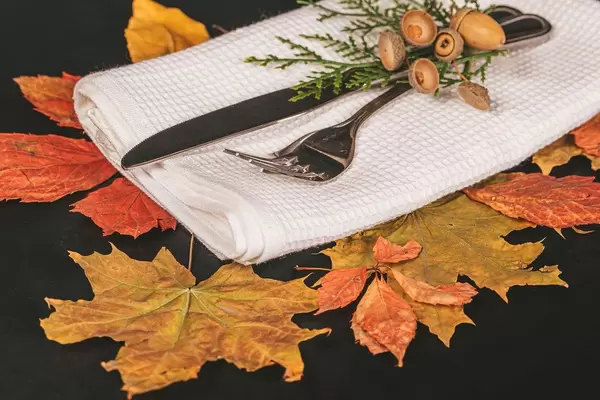 Fork and knife with autumn leaves and acorns