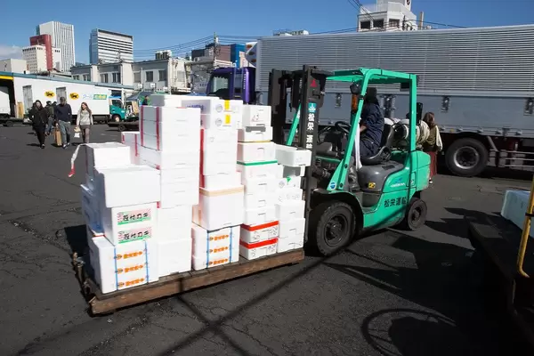 Fork lifter transports fresh food in white isolating boxes in Tokyo, Japan