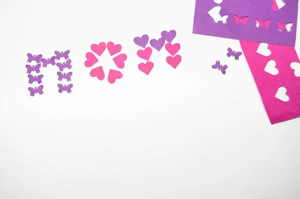 Forming the word MOM with paper cut outs