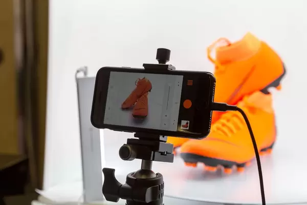 Fotografieren von orangen Nike Fussballschuhen gemacht mit Iphone am Stativ