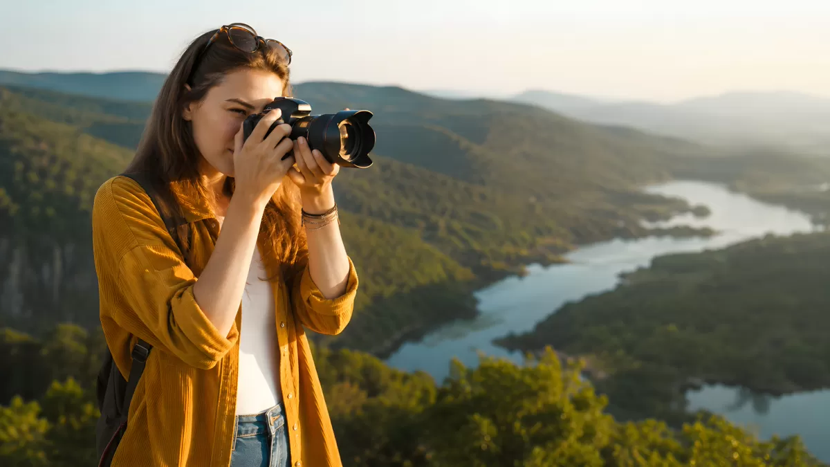 Fotografin auf Berggipfel mit Flusslandschaft