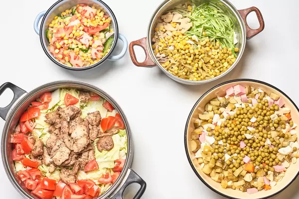 Four bowls with fresh vegetable salads and food