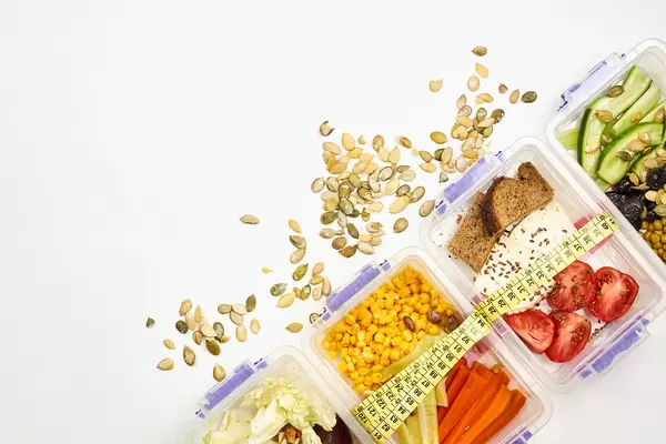 Four different healthy salads and pistachios on white background