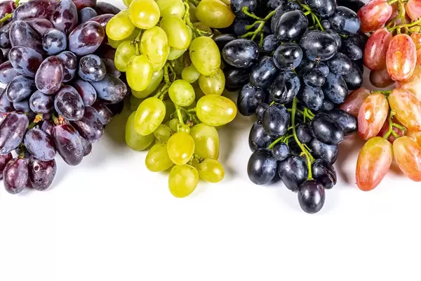 Four varieties of ripe grapes on white